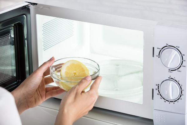Using Lemon or Citrus Peels A sliced of lemon in a bowl to clean the microwave oven